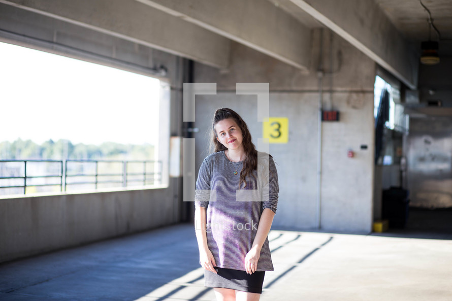 a woman standing in a parking garage 
