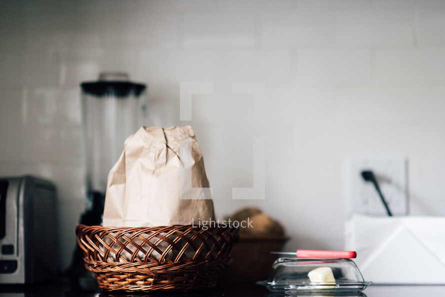 a paper bag in a basket in a kitchen 