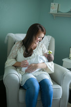 mother holding a swaddled newborn baby girl 