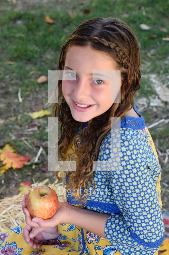 beautiful young girl holding an apple 