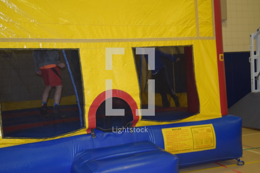 boys jumping in a bouncy house at a festival 