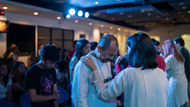 praying over another during a worship service 