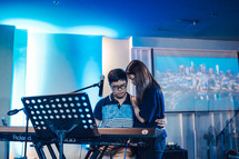 prayers over a piano during a worship service 