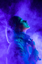 Young woman in neon purple-colored smokey scene