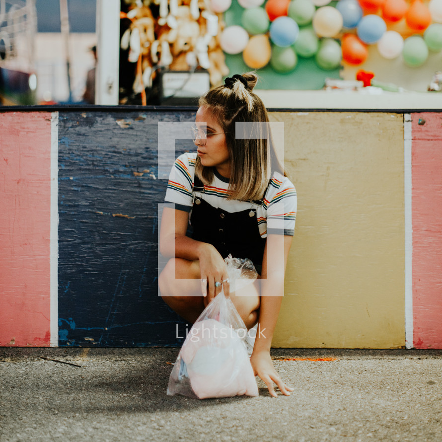 teen with cotton candy at a fair 