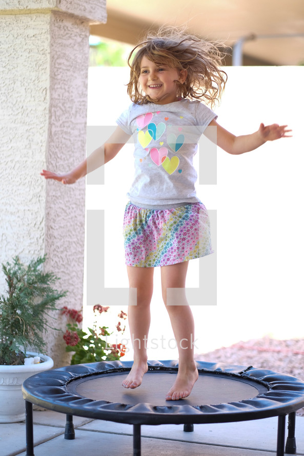 girl child jumping on a trampoline 
