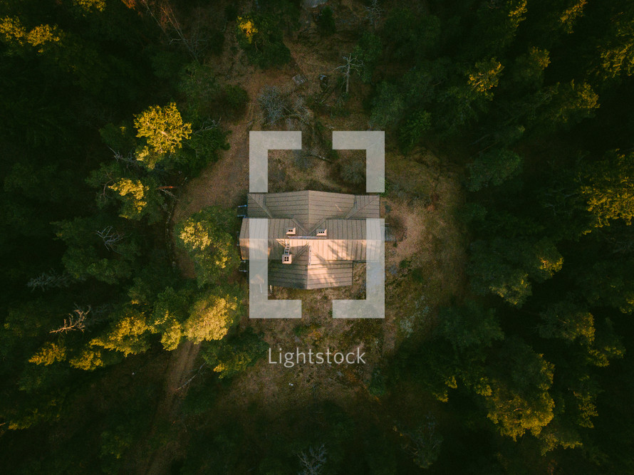 aerial view over a cabin in a forest 