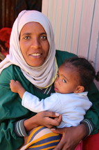 Ethiopian muslim woman holding her toddler daughter  [For more search Ethnic Face Smile].