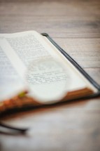 magnifying glass over the pages of a Bible 