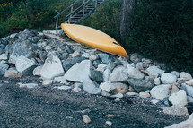 overturned canoe on a rocky shore 