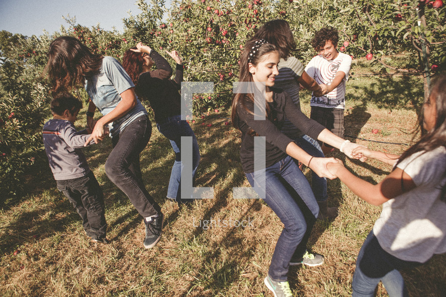 family dancing in an apple orchard 