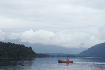 a woman paddling a canoe on a lake 