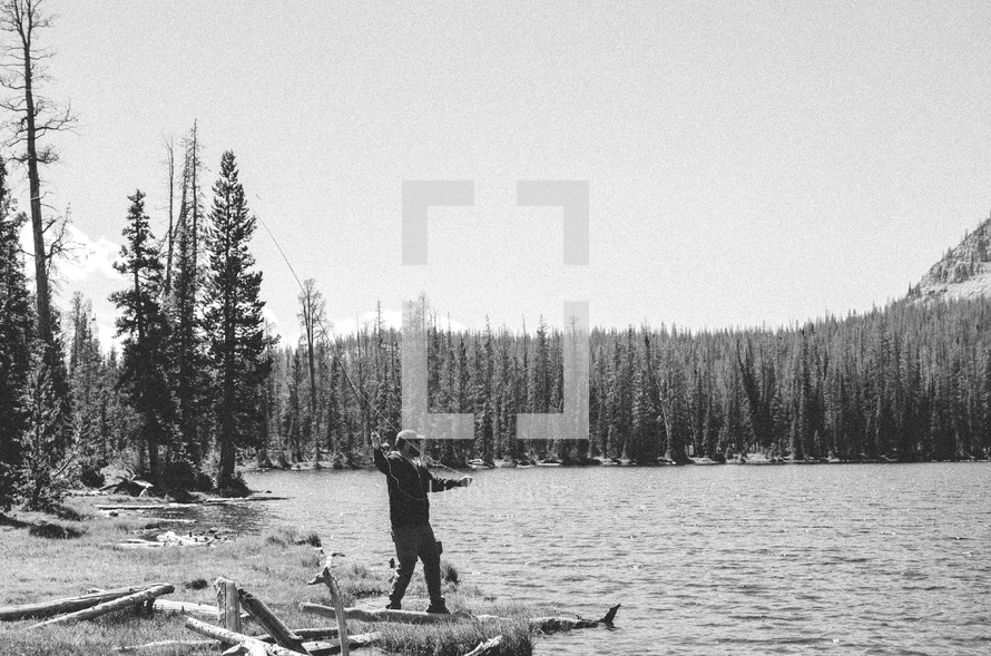 Man fly fishing, on a mountain lake.