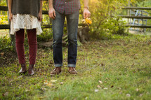 legs of a couple standing together outdoors 