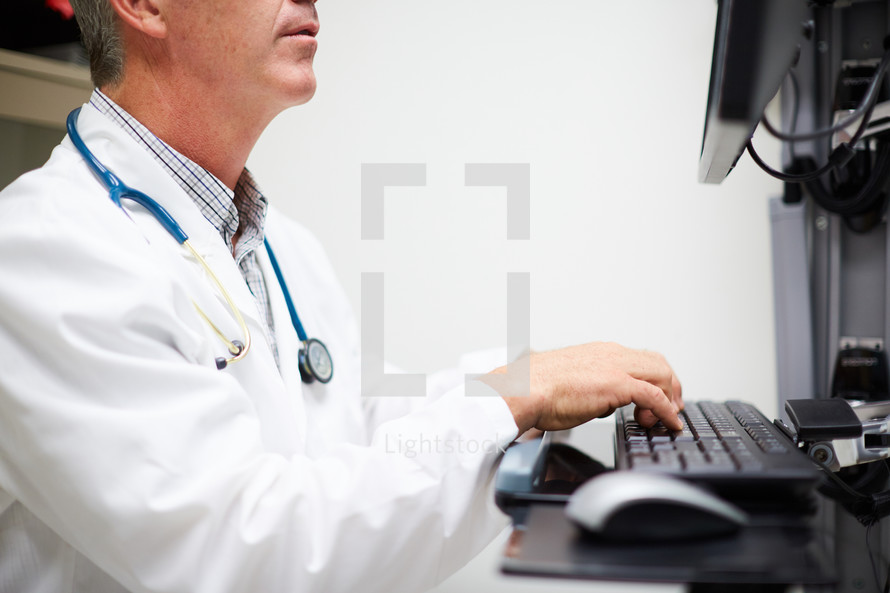 doctor typing on a computer 