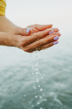Water pouring from womans hands
