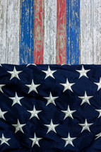 red, white, and blue stripes on weathered wood and stars of the American flag 