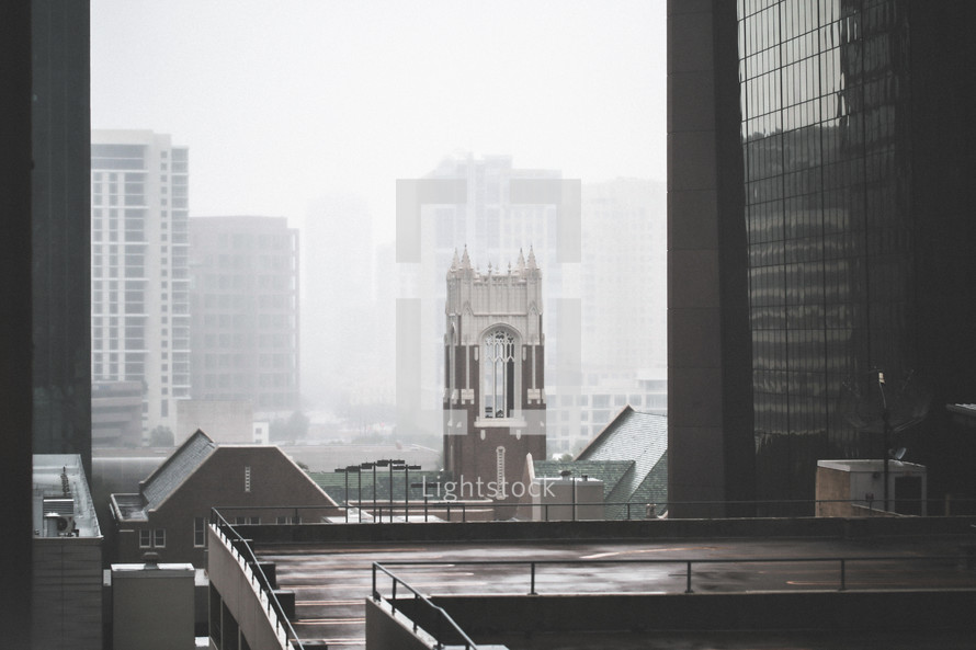bell tower in a city with fog 