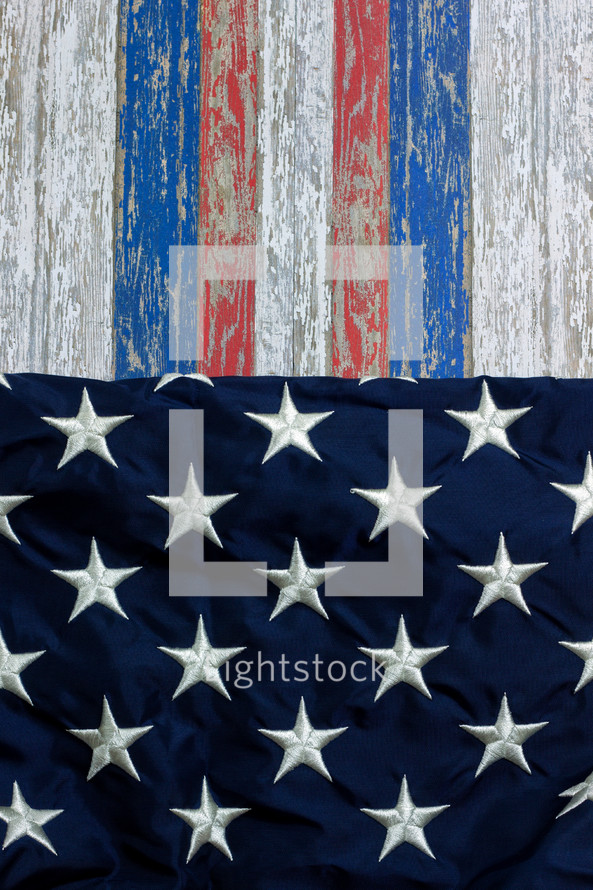 red, white, and blue stripes on weathered wood and stars of the American flag 