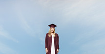 female graduate against a blue sky 