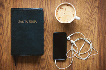 Santa Biblia, earbuds, iPhone, and cappuccino