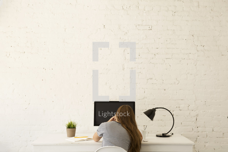 woman sitting at her desk working at a computer 