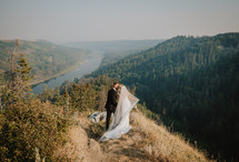 Bride and groom kissing at the top of a canyon.