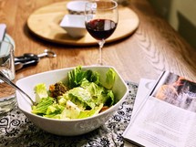 Salad and a glass of wine at a dinner table 