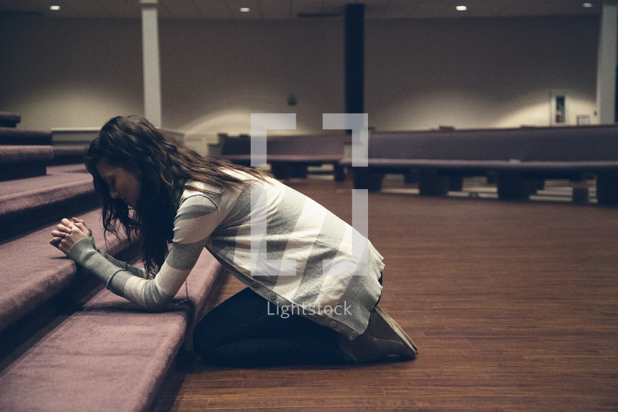 A woman kneeling in prayer 