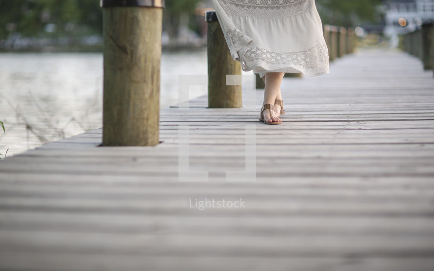a woman walking on a pier 