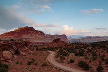 A road through the desert leading toward rocky mountains.