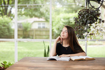 young woman reading a Bible on her porch 