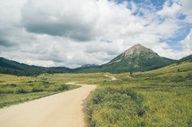 dirt road leading to a mountain peak 