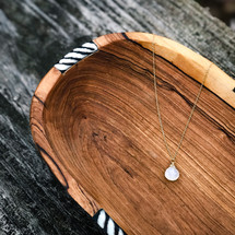 gold necklace in a wooden bowl 