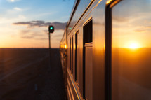 Train traveling through a desert land at sunrise.
