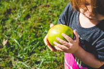 a girl holding an apple 