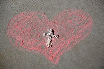 Ashes in the shape of a cross in a pink chalk drawn heart  - Ash Wednesday and Valentine's Day February 14, 2018