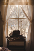 cowboy hat on a Bible in a window 