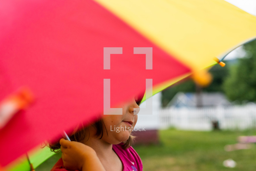 a little girl under an umbrella 