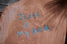 Jesus is my rock written on a rock in sidewalk chalk 