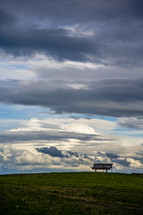 park bench on a mountain top under clouds 