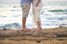 man and woman kissing on a beach 