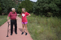 grandfather and granddaughter walking on a path 