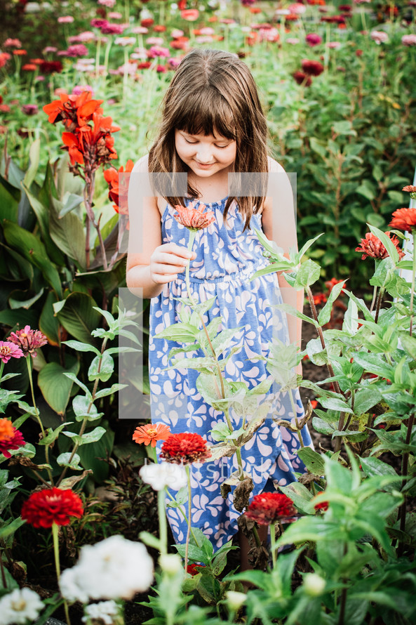 young lady smelling flowers in a blooming garden