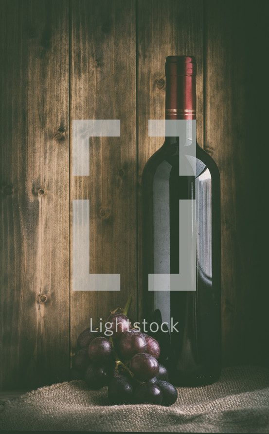 wine bottle and grapes on burlap 