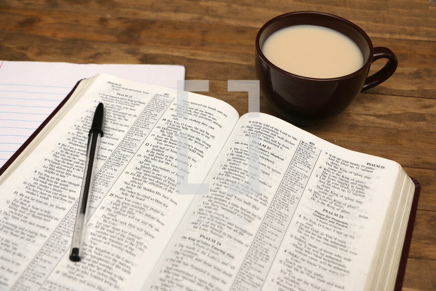 pen on an open Bible and coffee mug
