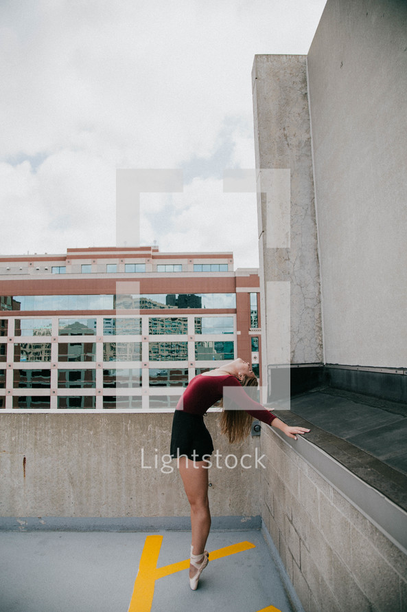 ballerina stretching on a rooftop 