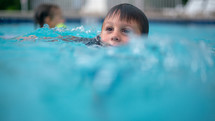 a boy swimming in a pool 