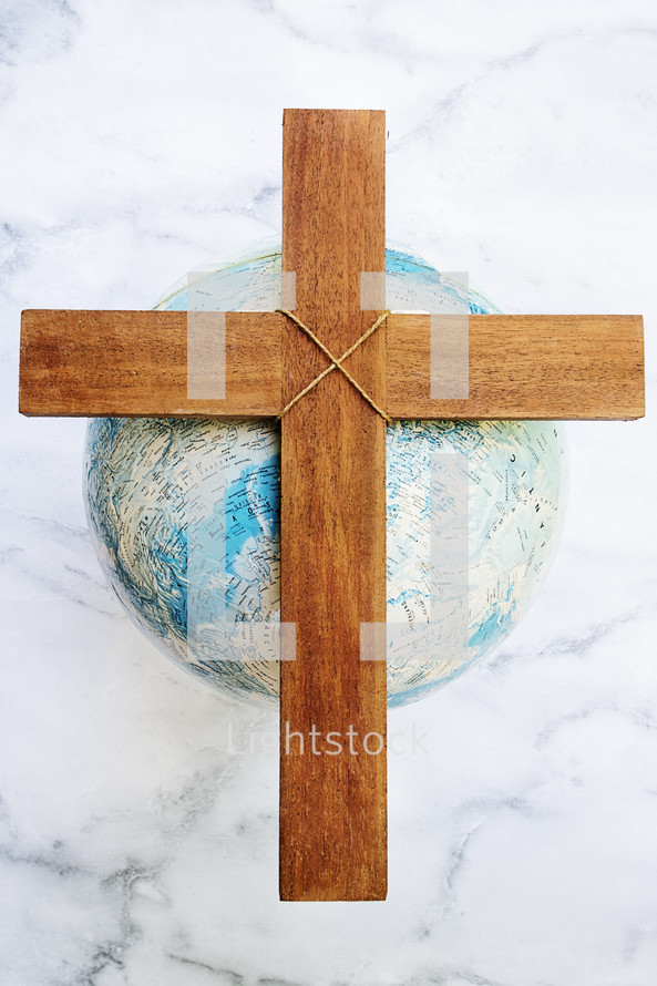 a wooden cross on a globe 