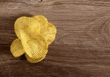 corrugated potato chips on wooden background